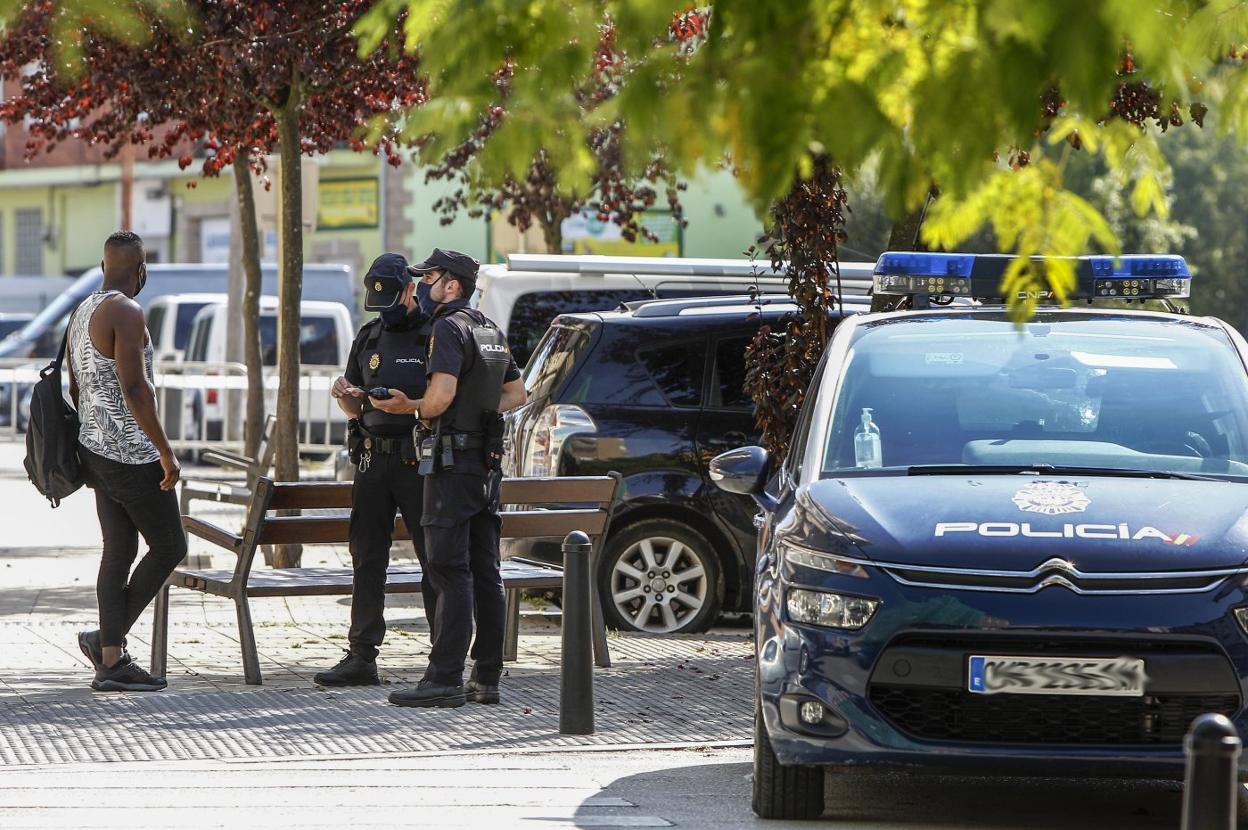 Dos policías identifican a un vecino de La Inmobiliaria en la zona de confinamiento. 