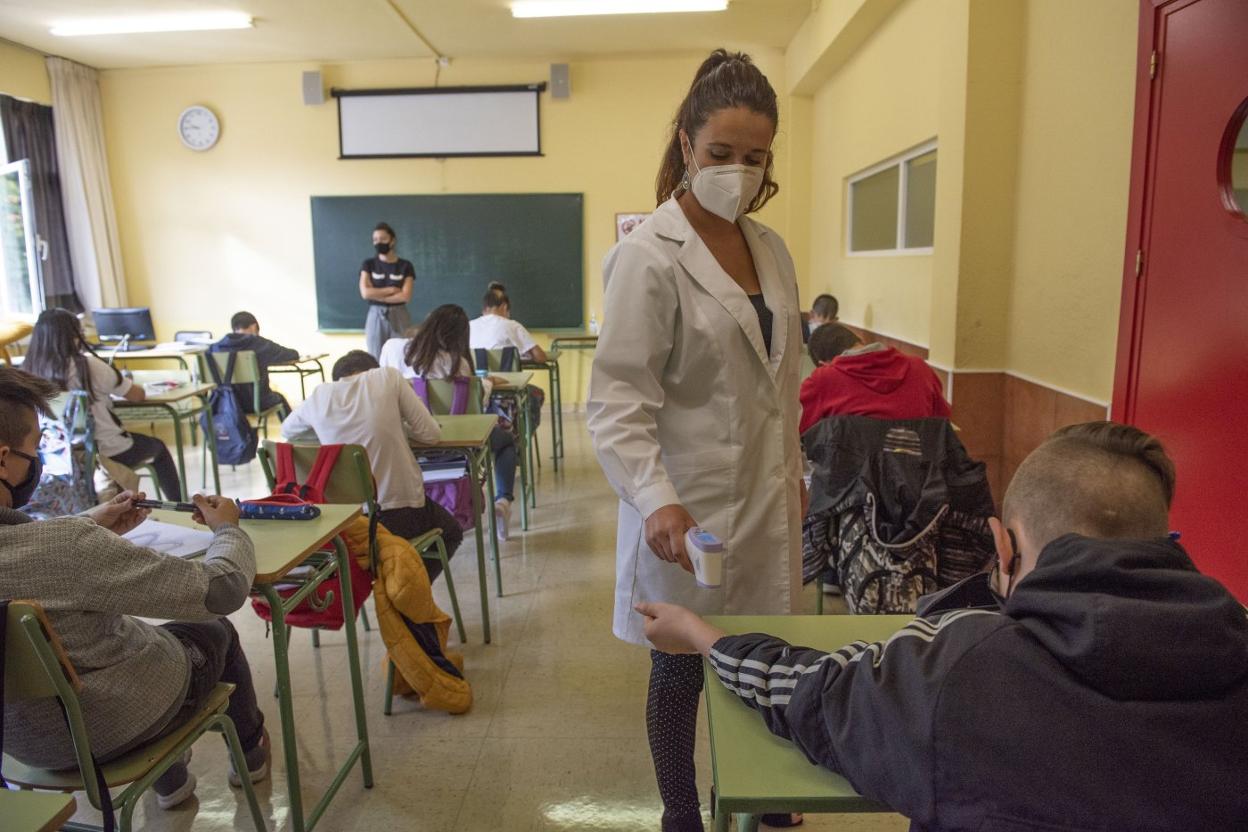 Los alumnos, con mascarilla, se toman la temperatura en el IES Montesclaros.