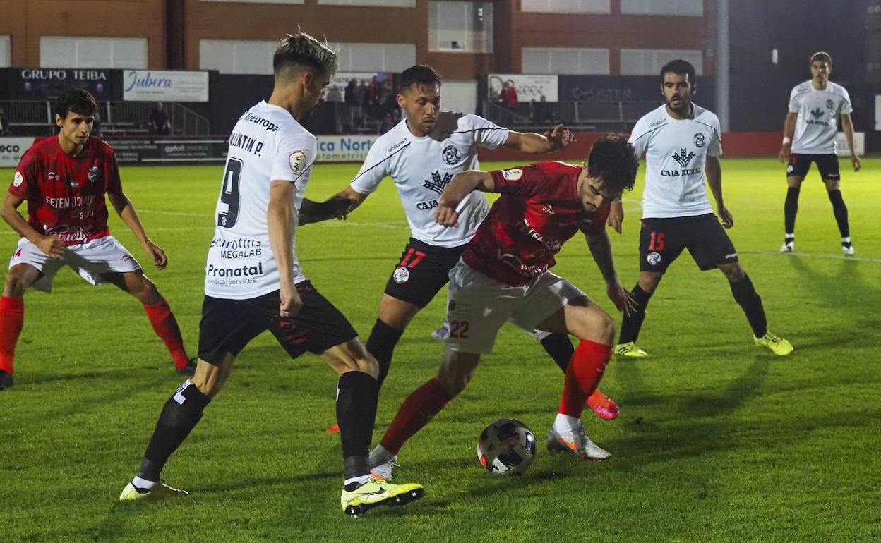 Juancar protege el balón ante la presión de dos futbolistas del Zamora. 