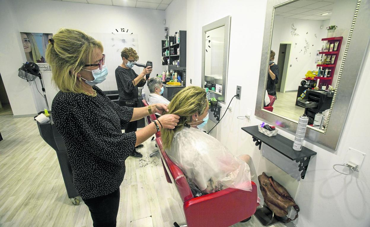 María Ángeles Olavarri atiende a una de las clientas de la Peluquería Yoan. 