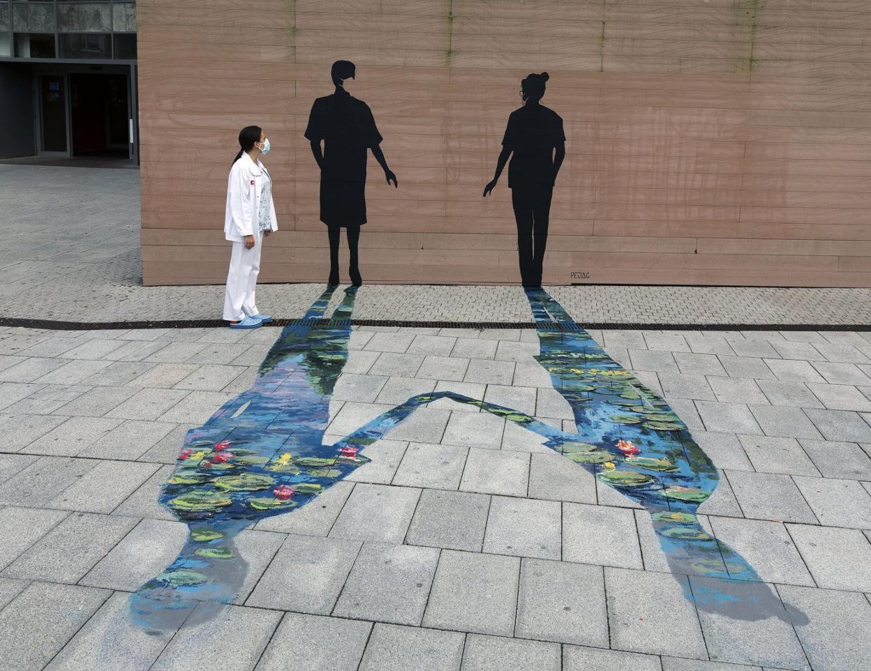 'Caricia', en la entrada a Valdecilla, es la obra más reciente de Pejac: dos siluetas que representan a los pacientes y al personal sanitario. 