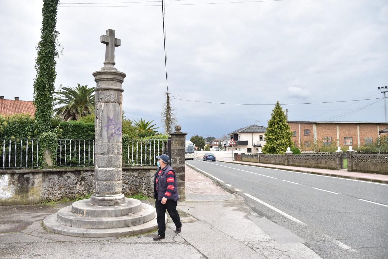 Un vecino camina junto al monumento, esta semana, en Revilla. j. g.