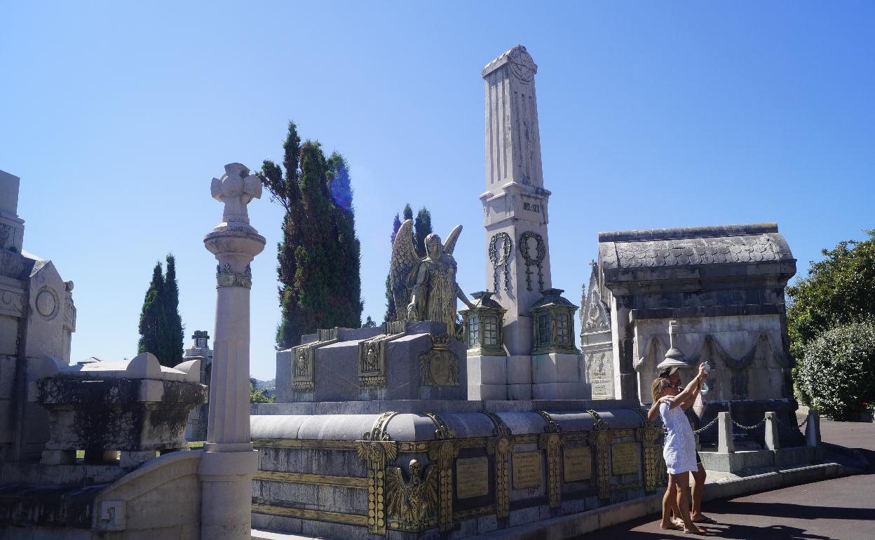 Una pareja se toma una fotografía frente al panteón de Leonardo Rucabado, en el cementerio de Ballena.