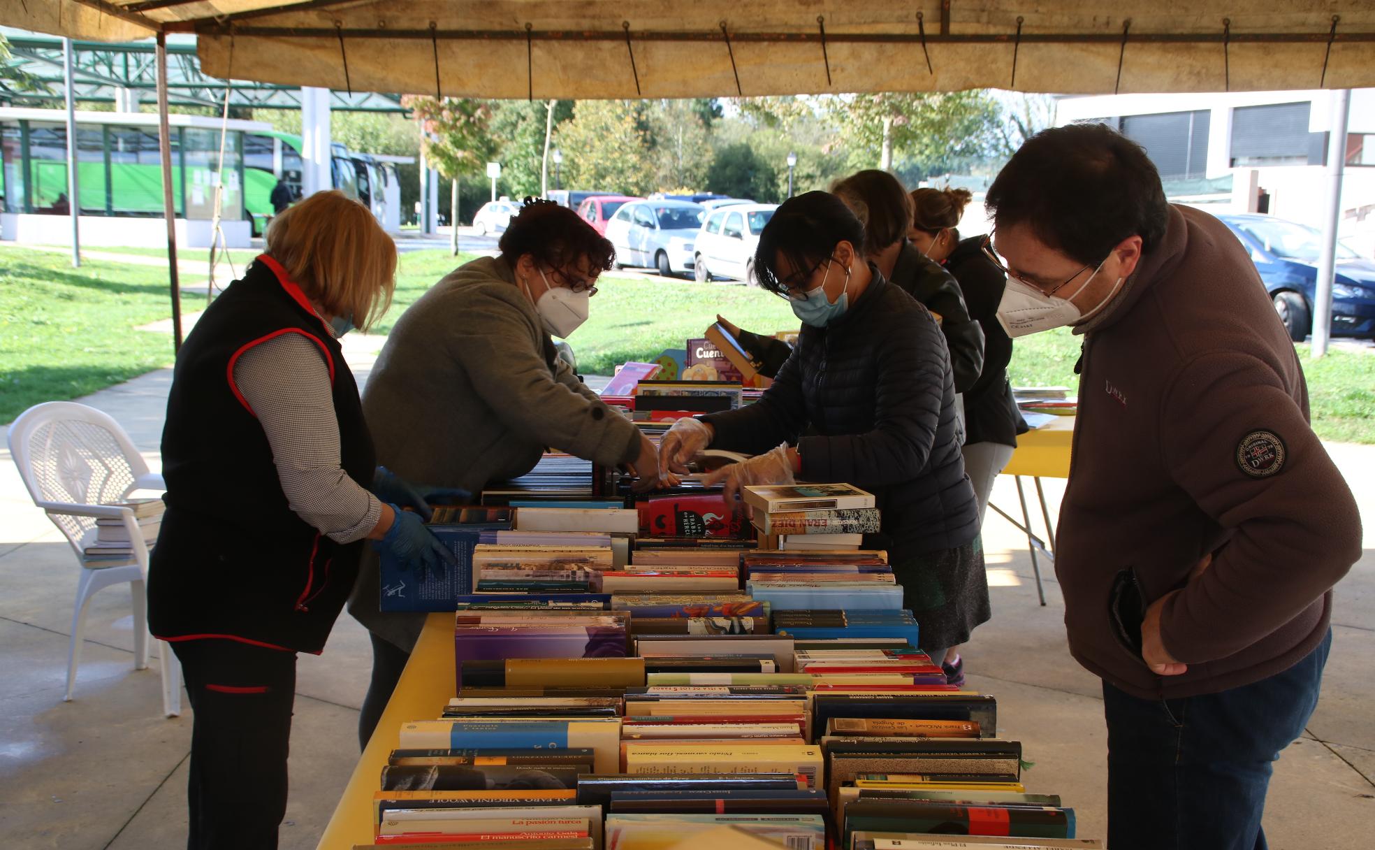 Vecinos ojean los libros donados a la Biblioteca de Sarón puestos a la venta 