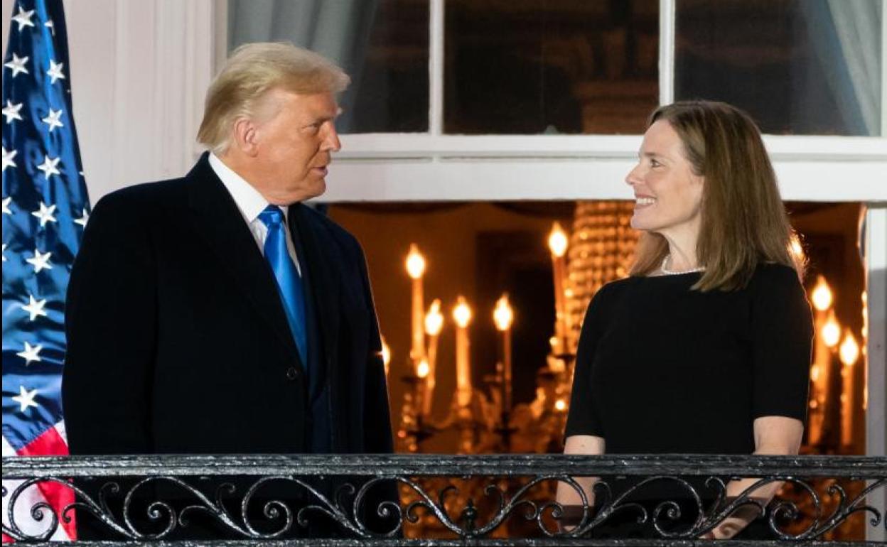 La jueza Amy Barrett conversa con Donald Trump.