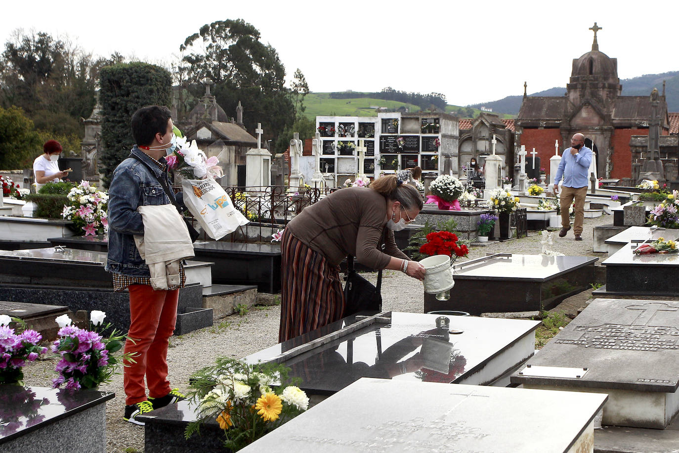 Los cántabros acuden a visitar a sus difuntos en los cementerios de la región en menor medida que otros años por las restricciones impuestas por el covid. En las imágenes, los camposantos de Ciriego (Santander) y Geloria (Torrelavega), esta mañana de Todos los Santos.