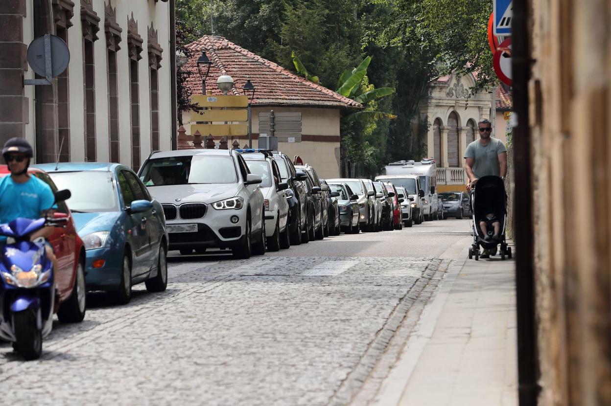 Un hombre atraviesa una de las calles de acceso a la villa con un carrito de bebé. 