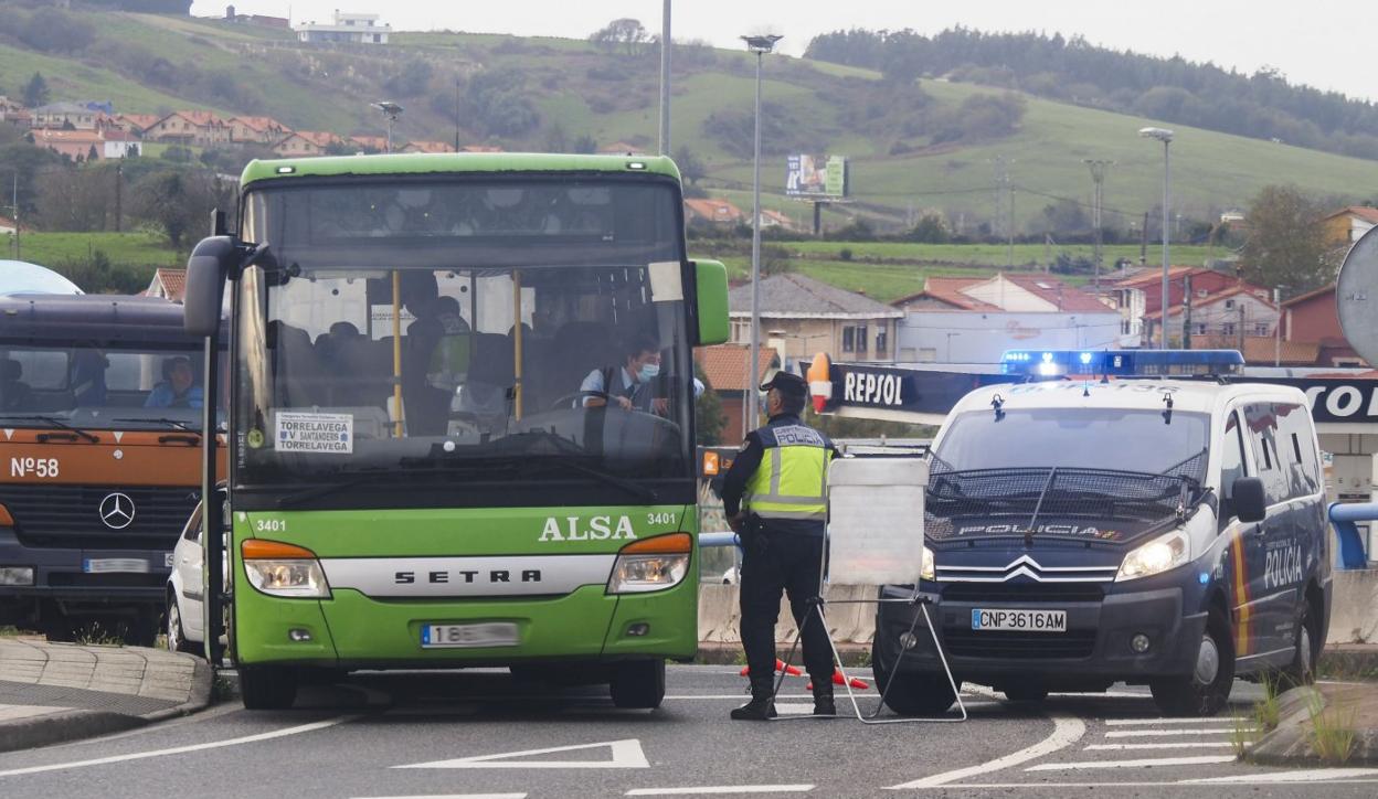 Un agente para a un autobús en la rotonda de Ojáiz.