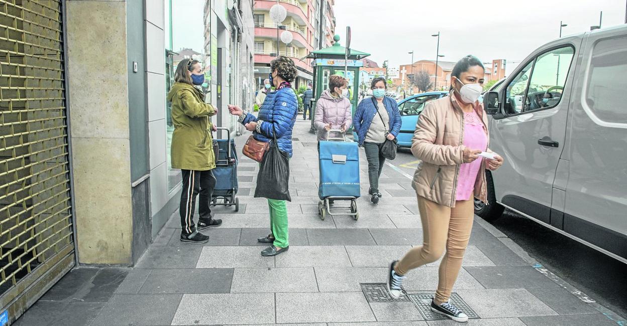 Unas vecinas caminan por la avenida Menéndez Pelayo, este viernes, en el casco urbano de Muriedas. 