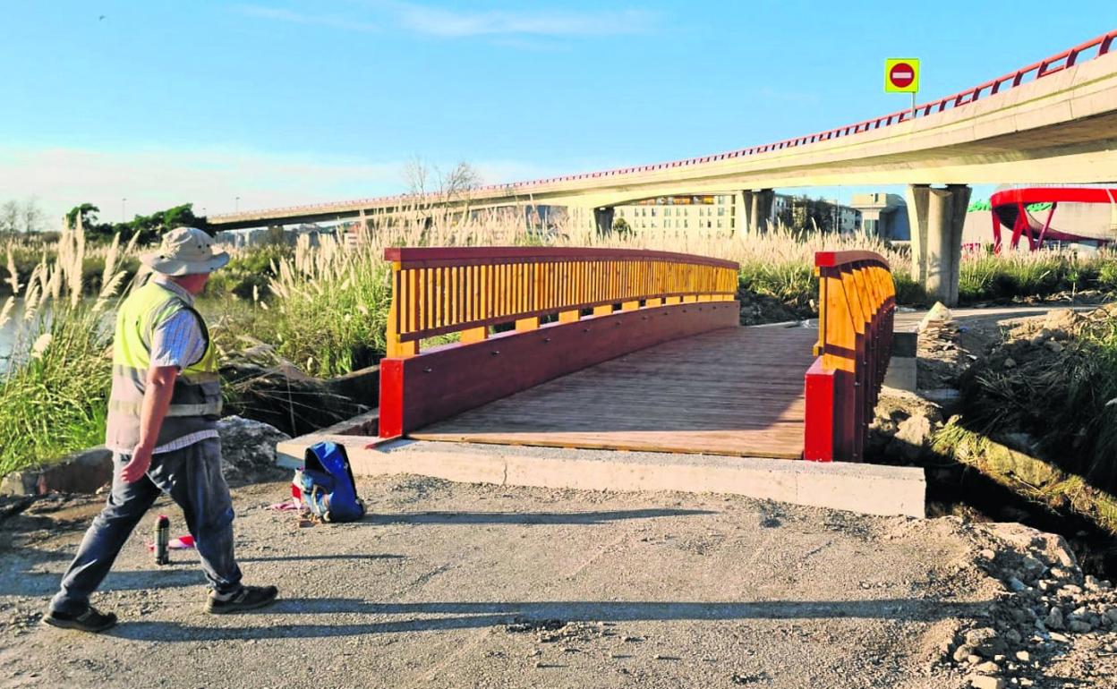 Un responsable de obra camina hacia la pasarela de la conexión del carril bici, este viernes, en la Marisma de Alday, entre Camargo y Santander.