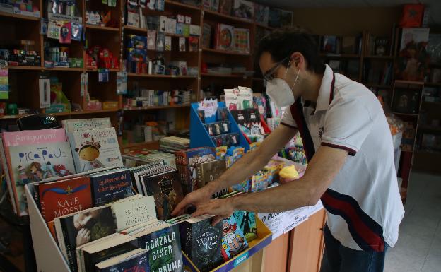 Óscar Ordóñez, de la librería y perfumería 'Madeira', coloca uno de los mostradores de su negocio 