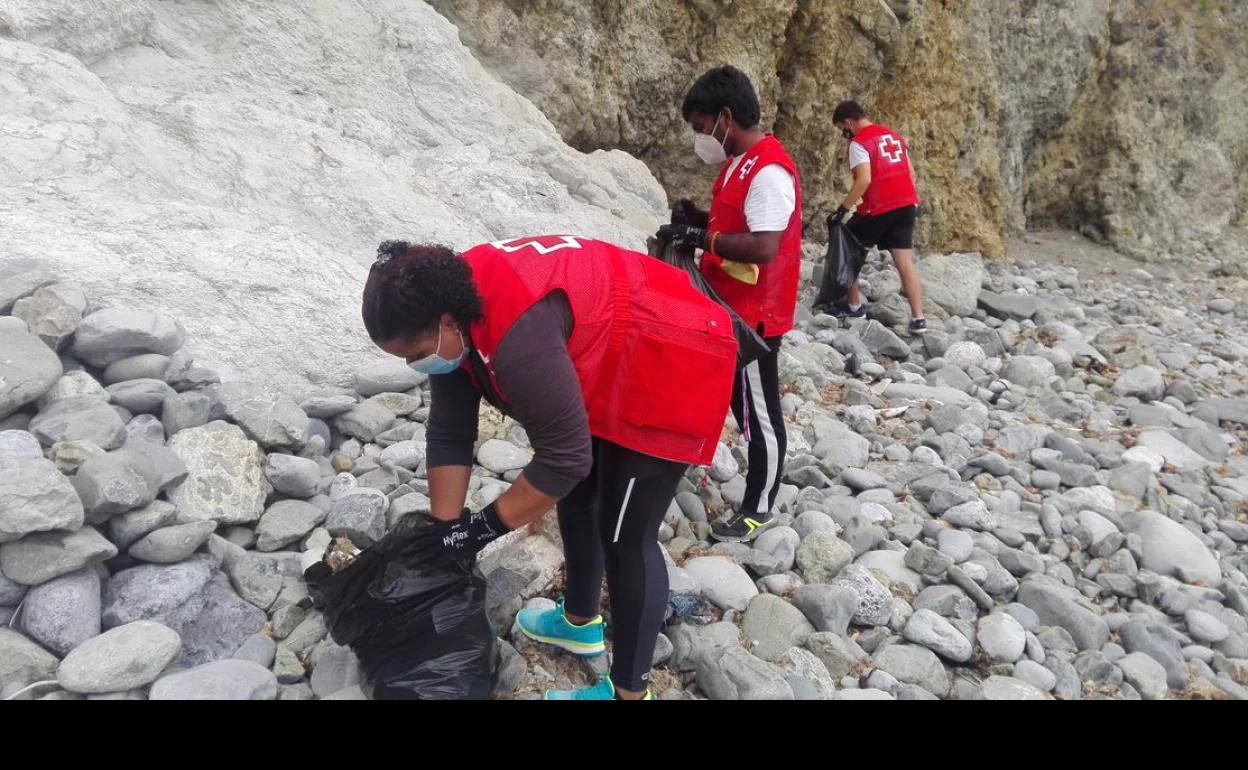 Voluntarios de Cruz Roja Cantabria realizando la actividad de recogida de basura 