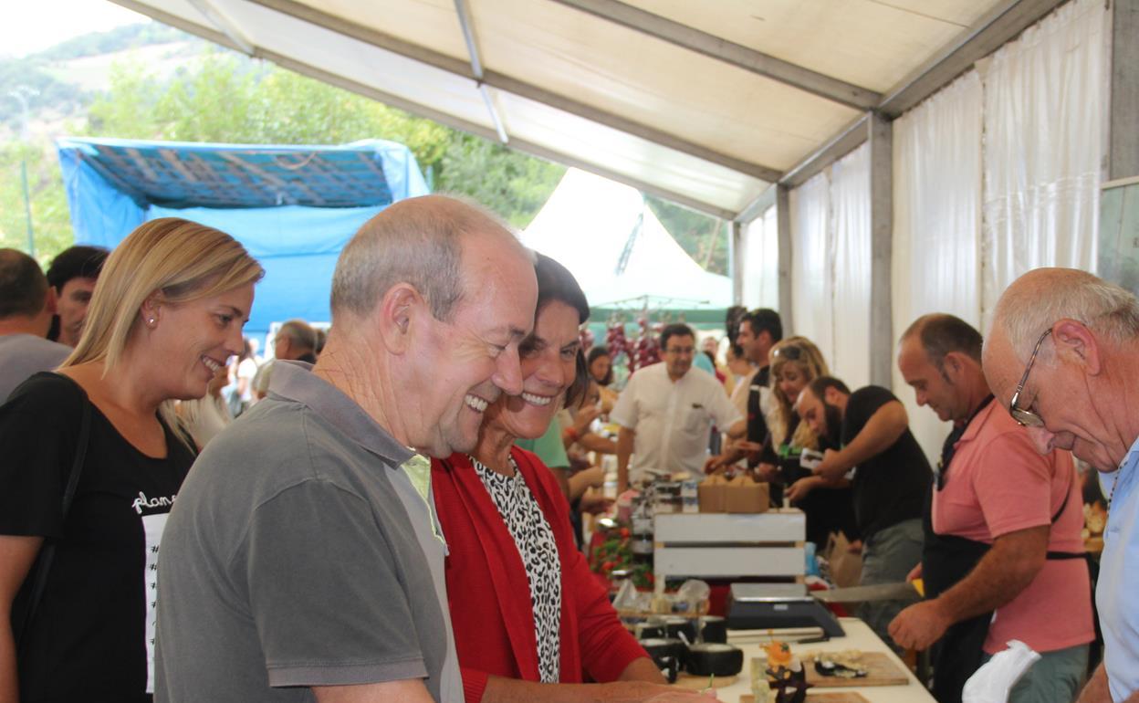 Una familia compra miel de Liébana con DOP en la feria de la miel del pasado año en Vega de Liébana 