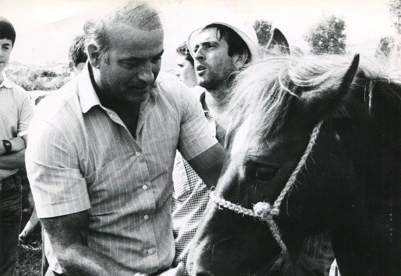 Imagen antigua de Juan Hormaechea Cazón acariciando a un caballo en un mercado.