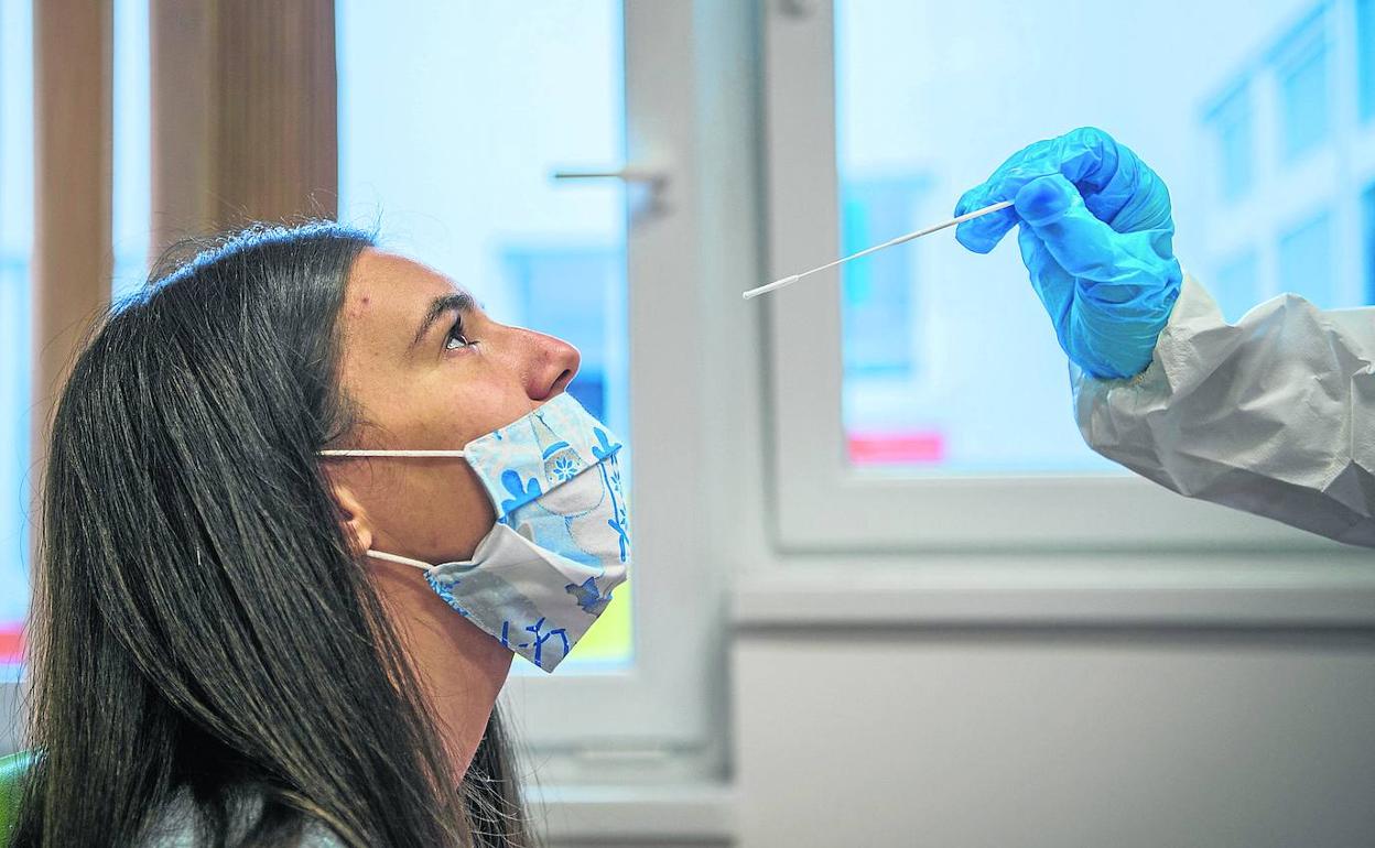 Una joven espera a que le tomen la muestra nasofaríngea para realizar la PCR, la prueba por excelencia del coronavirus.