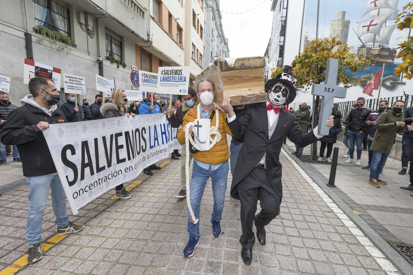 Decenas de hosteleros han protagonizado esta mañana una sonora protesta en Peña Herbosa frente a la sede del Gobierno de Cantabria. Mientras dentro del edificio se anunciaba que se prohibirá la apertura del interior de los locales durante toda la Navidad, fuera los damnificados escenificaban su funeral, con ataúdes y sogas al cuello.