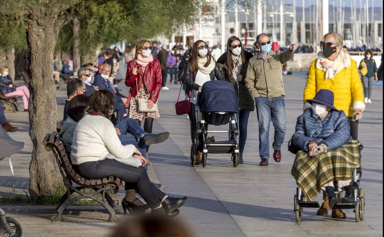 Paseantes por la bahía de Santander, ciudad que gana población por tercer año consecutivo.