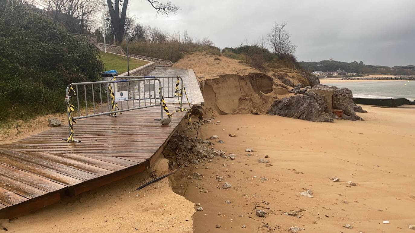 El paseo de El Sardinero está cubierto de agua y arena, mientras en la playa de Los Peligros aumenta el socavón bajo la pasarela de acceso y la lluvia forma una gran balsa en las inmediaciones del desprendimiento de Reina Victoria.