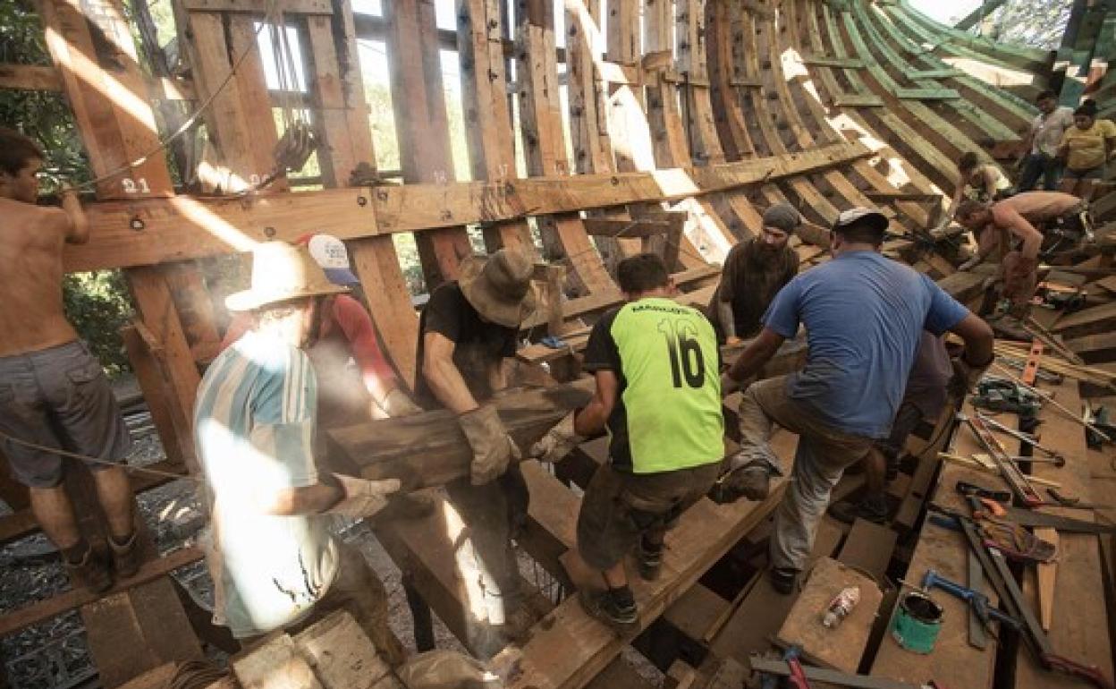 Los constructores del barco de tres mástiles, durante su construcción.