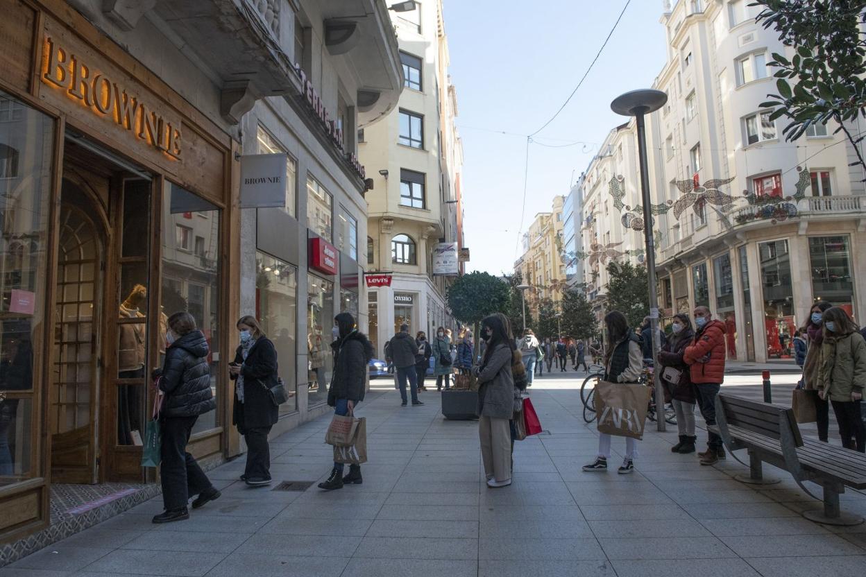 Varias compradoras esperan en fila para poder acceder a una tienda de ropa en el centro de Santander en el primer día de rebajas.