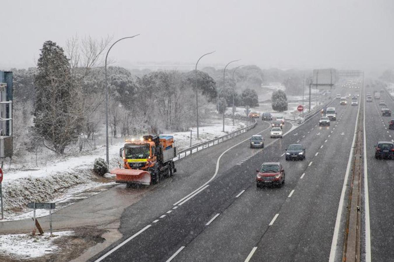 Una quitanieves lista para trabajar mientras varios vehículos circulan por la Autovía A5 a la entrada de Madrid.