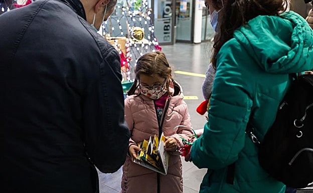 Una de las pequeñas dibujantes comprueba el resultado final del cuento realizado con creaciones suyas y más niños del municipio 