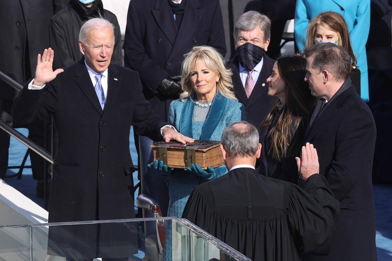 Joe Biden jura su cargo como presidente de Estados Unidos mientras su esposa Jill sujeta la Biblia. 