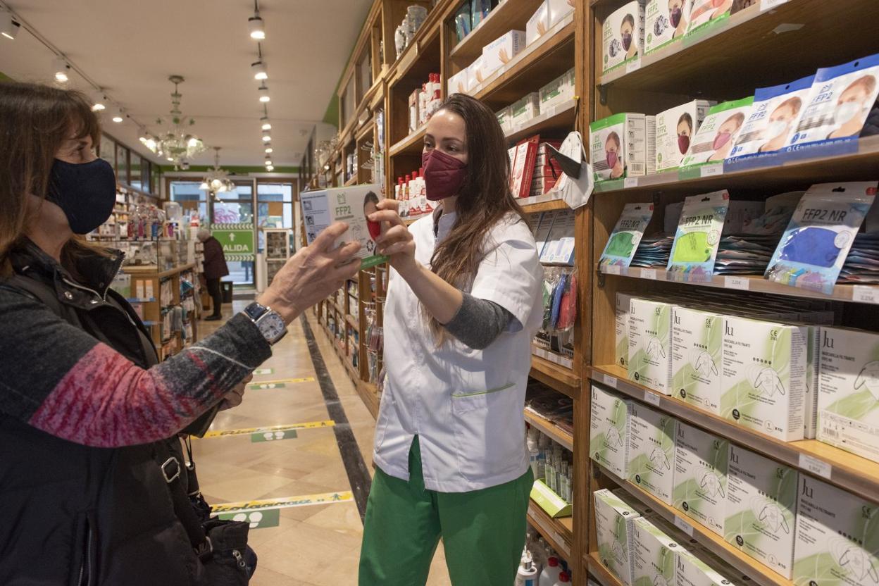 Carolina del Cerro, trabajadora de la Farmacia Navedo Alonso, atiende a una cliente, este viernes, en Santander. 