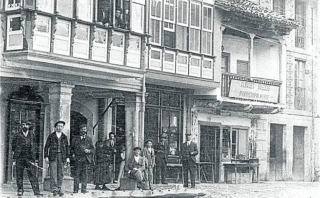Imagen principal - Arriba: La Plaza y entrada a la calle Cántabra.. Abajo: Vecinos y soldados pasan junto a las ruinas de la Plaza y Grupo de personas durante una comida en Casa Susa.