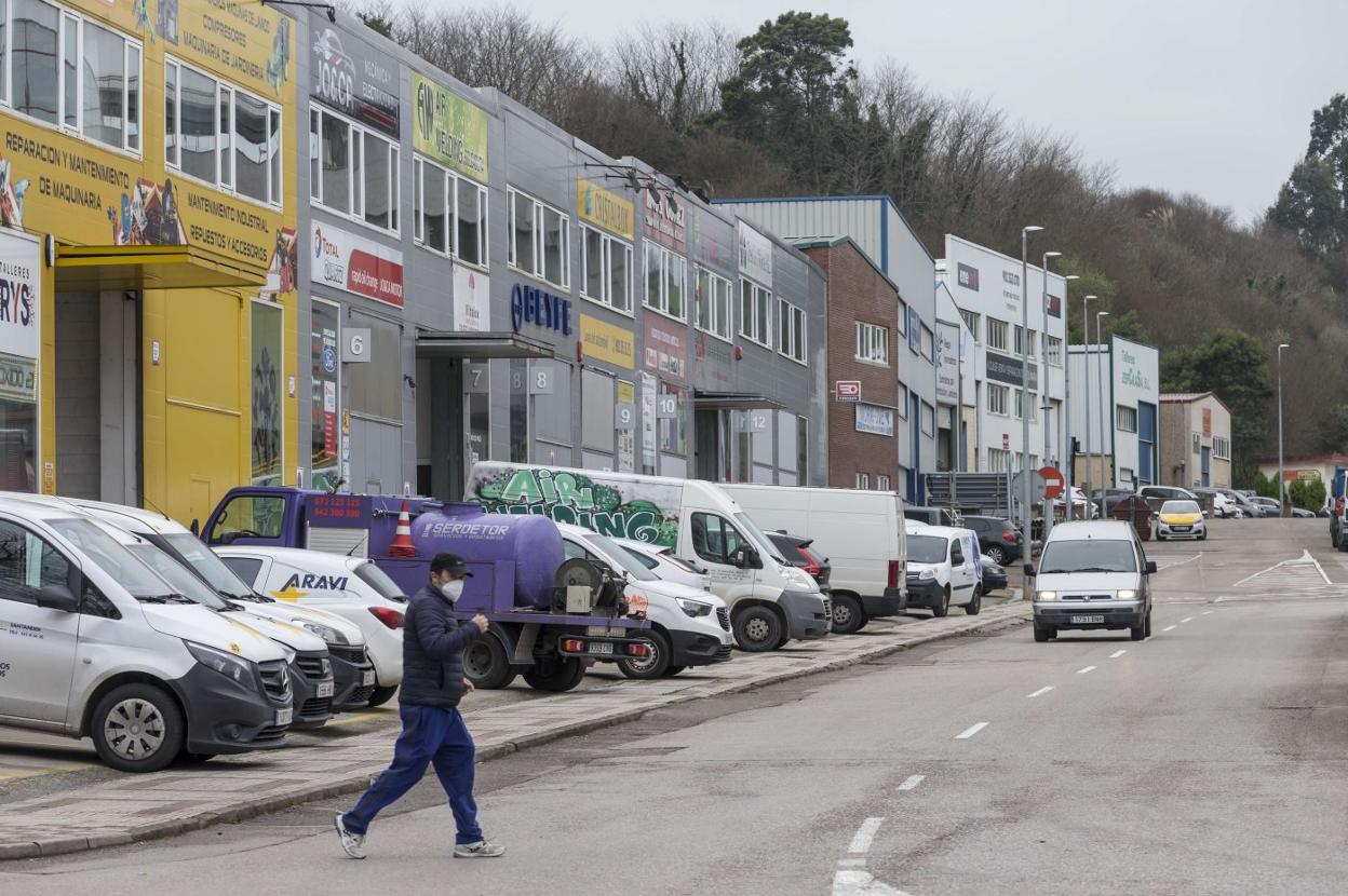 Un vecino cruza la calle en plena entrada hacia el polígono de Trascueto, donde se instala un centenar de empresas en Revilla de Camargo. 