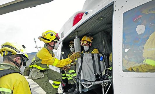 Dos de los especialistas acceden al helicóptero. 