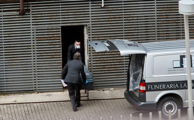Los trabajadores de una funeraria trasladan el cuerpo de un fallecido en Valdecilla por el covid 19.