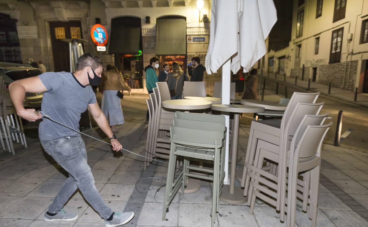 Hostelero recogiendo su terraza, antes del toque de queda de las 22.00 horas.