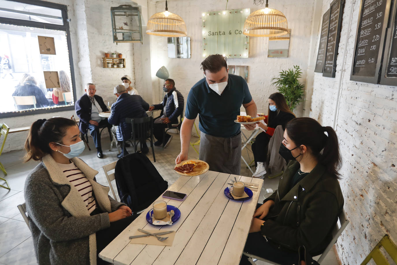 El buen tiempo mantiene las terrazas llenas, los clientes apenas se han enterado de que ya pueden usar el interior y los que lo saben se sienten más seguros en la calle. Ese es el panorama que presenta un recorrido por el centro de Santander