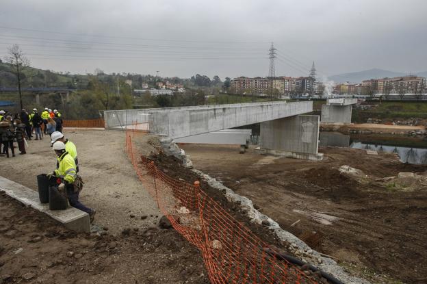 Vista de las obras de construcción de la pasarela sobre el río desde la orilla próxima a Sniace, al complejo deportivo Óscar Freire y a la finca del Patatal. 