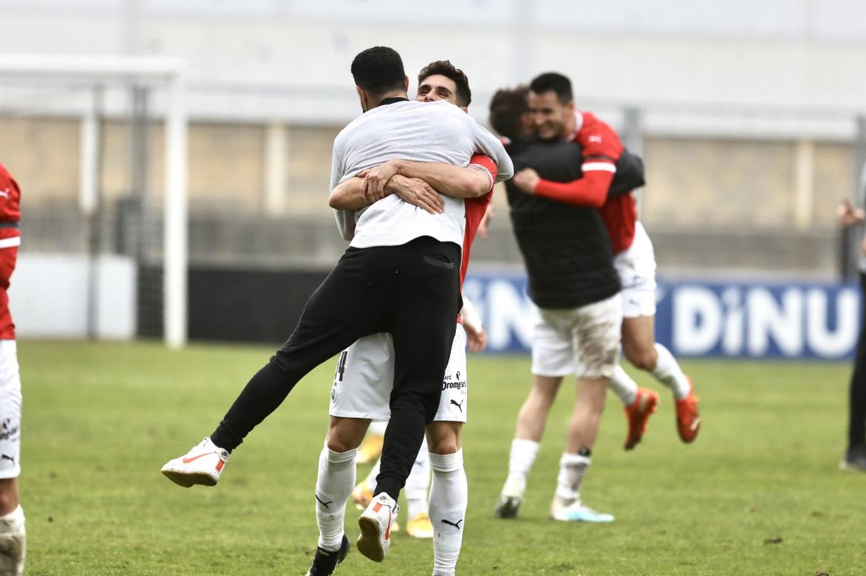 Óscar Gil se abraza con Álvaro Bustos en Irún. Al fondo, Jon Ander hace lo propio con Isma López. 