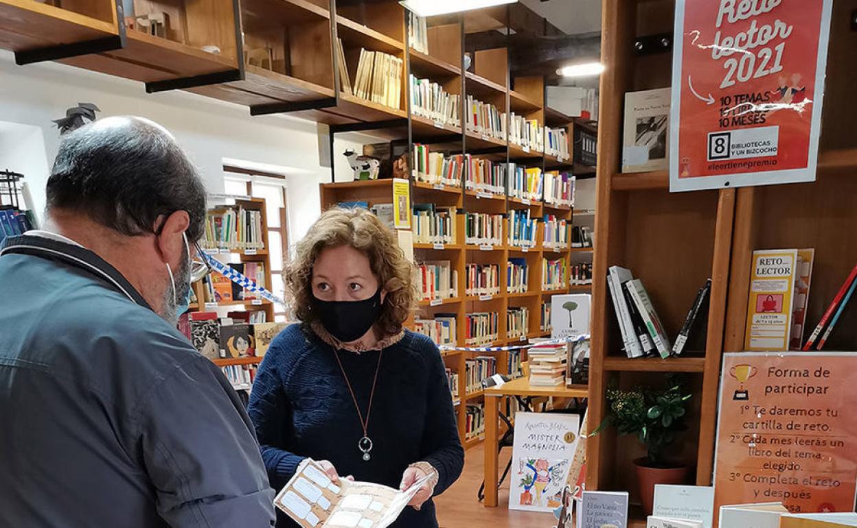 La bibliotecaria, Ana Lilia, le explica a un vecino en qué consiste el reto lector en la biblioteca municipal. 