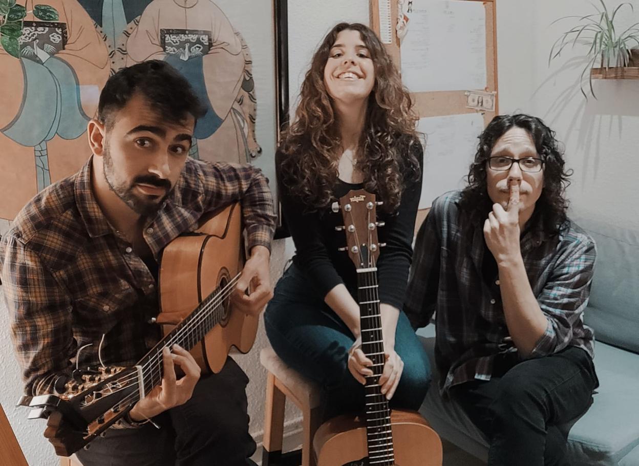 La pintora Lucía Moure custiodiada por los músicos Juanpy Arnedo y Pablo Díaz.