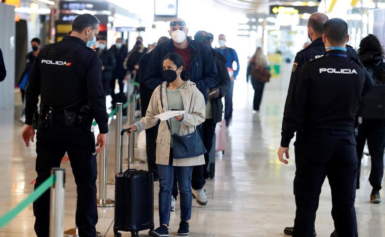 Policías comprueban la PCR de una viajera en Barajas.