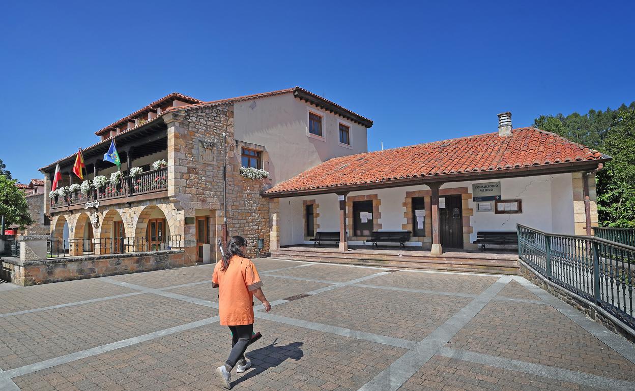 Una mujer atraviesa la plaza del Ayuntamiento en Novales, Alfoz de Lloredo. 