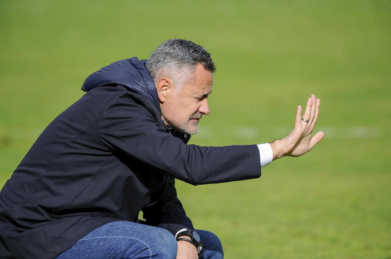 Manu Calleja, en cuclillas, da instrucciones a sus futbolistas. 