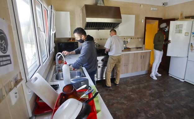 Junto a sus compañeros en la cocina de la casa, haciendo sus labores.