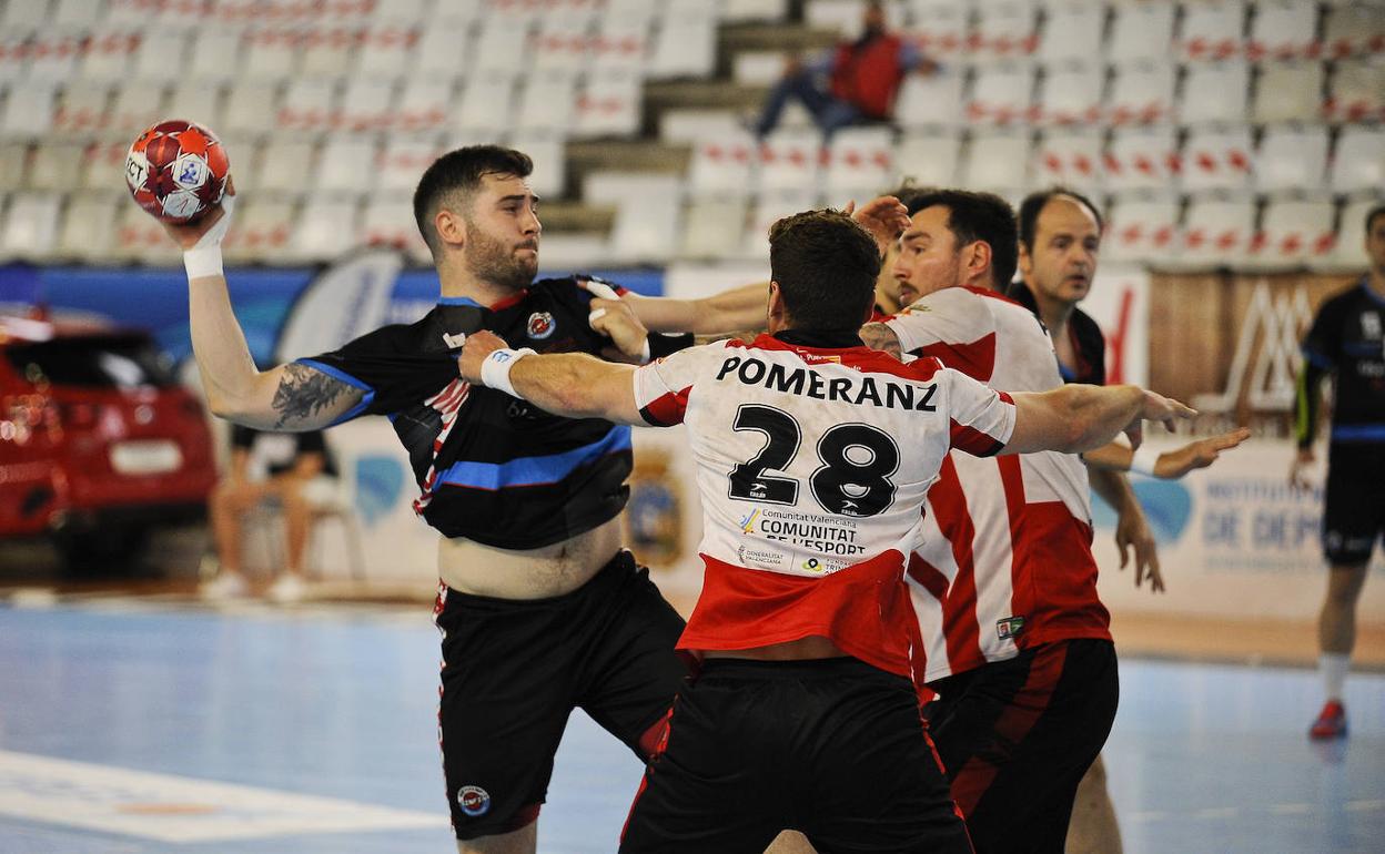 Castro, del Sinfín, trata de lanzar ante Pomeranz, del Puerto Sagunto, en un partido en La Albericia. 