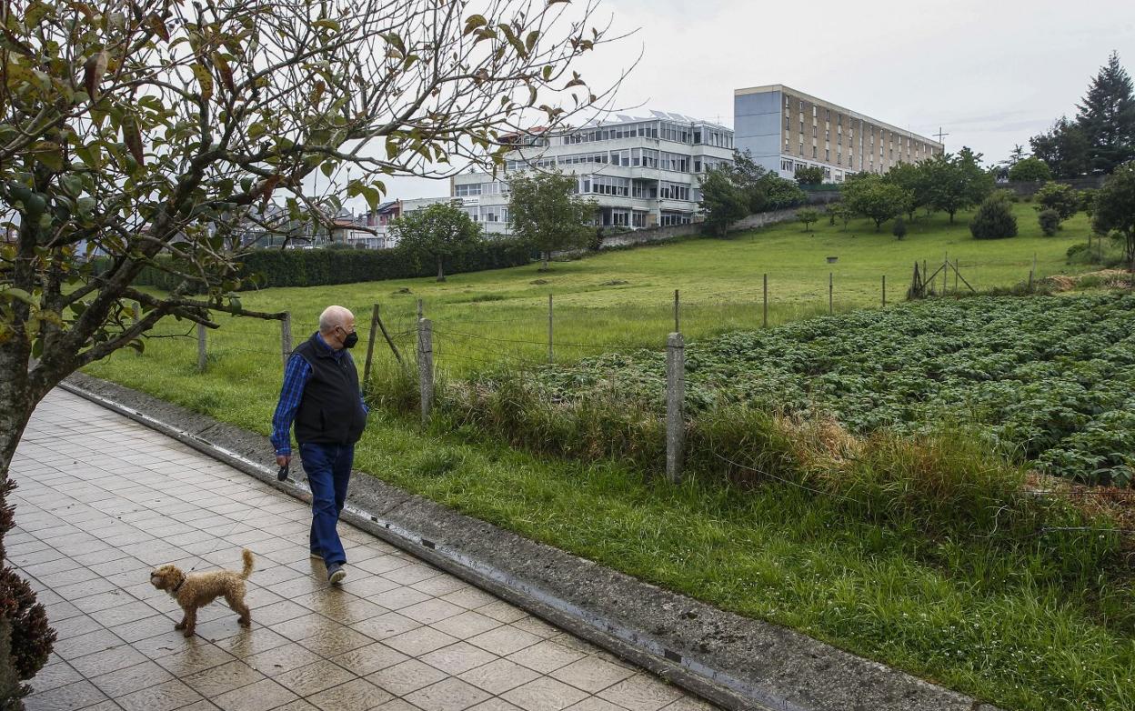 Un hombre, junto a su perro, camina junto a la parcela en la que se construirá el nuevo Conservatorio de Música, en la zona de El Valle. 