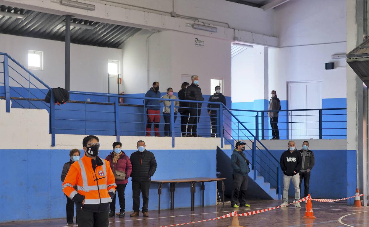 Vecinos haciendo cola ayer en el polideportivo 