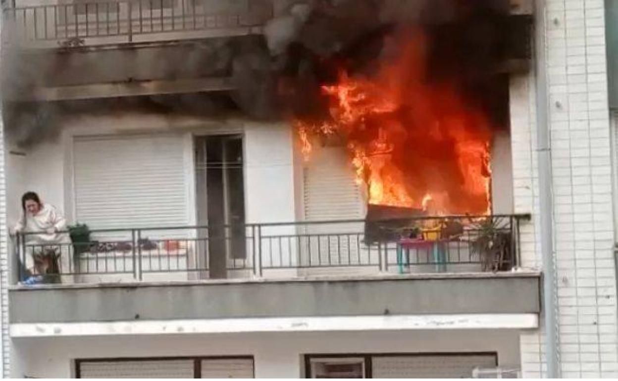 Una mujer atrapada en el balcón por el fuego pide auxilio para que la rescaten.