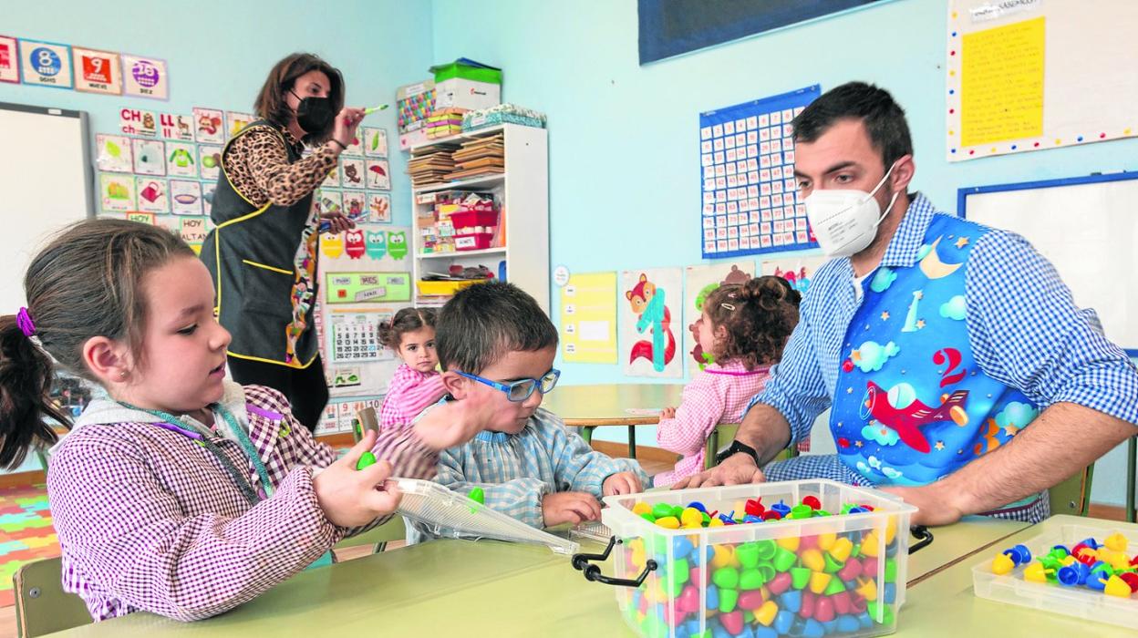 La maestra Davinia Pérez Fernández y Antonio Amavisca Incera, técnico de Infantil, en el aula con su alumnado. 