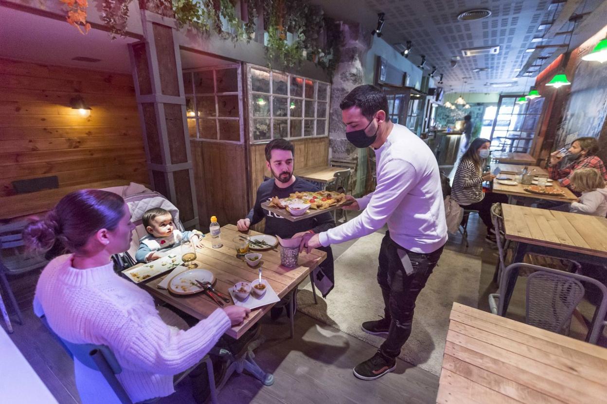 Una familia come en el interior de un restaurante, cuando las restricciones lo permitían. 