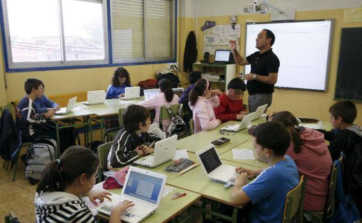 Alumnado y profesor trabajan con ordenadores portátiles