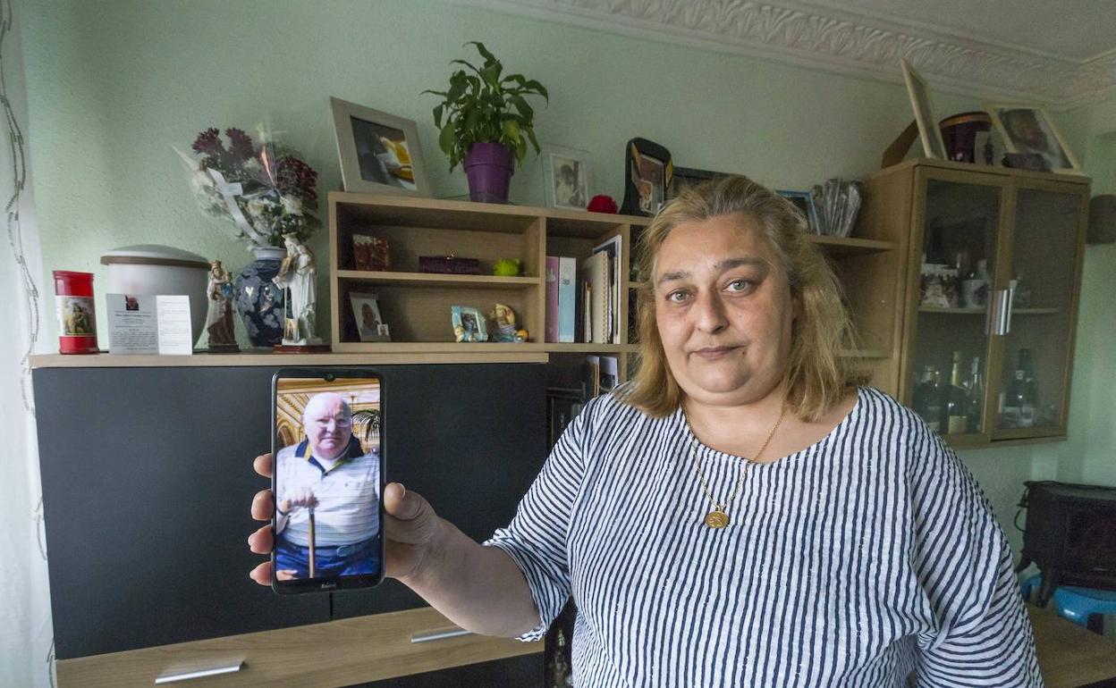 Rosa María Ceballos muestra en el móvil una fotografía de su padre, fallecido por covid. 